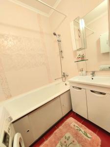 阿拉木图HappyTerra, район ТРЦ "АДК"的浴室设有白色浴缸、水槽和镜子