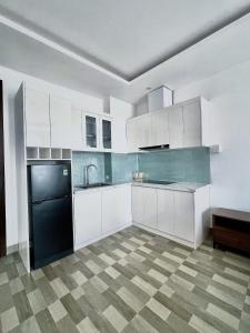 海防Minh Anh Hotel & Apartment的厨房配有白色橱柜和黑色洗碗机