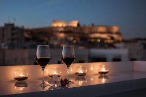 雅典卫城精选酒店的两杯酒坐在一张带蜡烛的桌子上