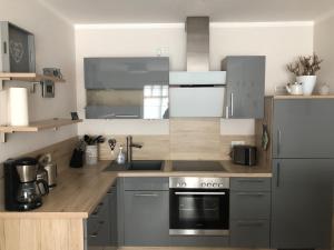 海利根达姆Lindenpalais Wohnung 24的厨房配有不锈钢用具和木台面