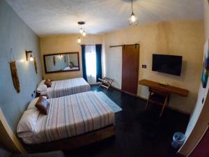 Cárdenasrelax hotelito的酒店客房设有两张床和电视。