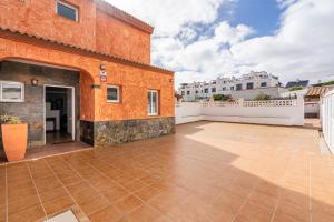 科拉雷侯Villa Paraíso的一座带橙色建筑和白色围栏的户外庭院