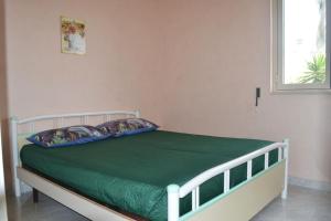 新福卡Casa vacanze Ll09 50m mare San Foca的一间卧室配有一张带绿色床单的床和一扇窗户。