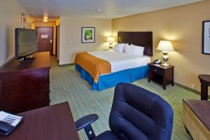 滑铁卢Holiday Inn Express- Waterloo/Cedar Falls, an IHG Hotel的一间酒店客房,配有一张床和一台电视