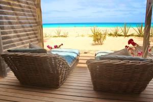 萨尔雷Villa Cristina Alojamento, Praia de Chaves, Boa Vista, Cape Verde, WI-FI的一个带2把藤椅的门廊和海滩