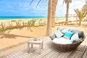 萨尔雷Villa Cristina Alojamento, Praia de Chaves, Boa Vista, Cape Verde, WI-FI的海滩旁甲板上的藤椅