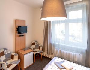 Srbsko尤贝龙卡酒店的客房设有床、椅子和窗户。