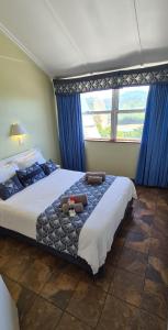 斯科特堡Pearly Shells的一间卧室配有一张大床、蓝色窗帘和窗户
