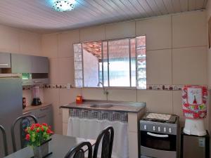 拉巴拉德纳圣米格尔Conforto 100 mts da praia的厨房配有水槽和炉灶 顶部烤箱
