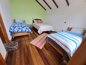 Comunidad YumaniHostal Palacio del Inca的铺有木地板的客房内的两张床
