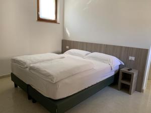 圣塔布罗焦迪瓦尔波利切拉Agriturismo Ca' Verde的卧室内的一张带白色床单和枕头的床