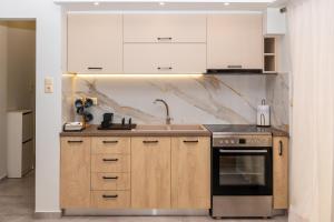 卡拉马塔P&K LUXURY APARTMENTS 2的厨房配有白色橱柜、水槽和炉灶。