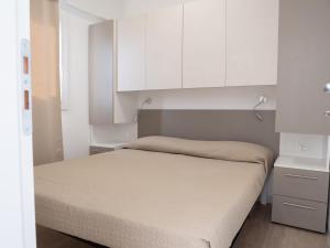莫诺波利Santo Stefano Village的一间小卧室,配有一张床和白色橱柜