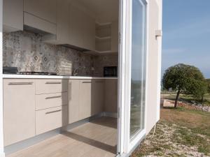 莫诺波利Santo Stefano Village的一间厨房,配有白色的橱柜和大窗户
