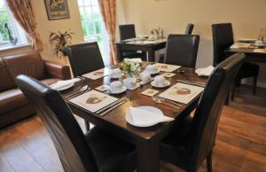 文斯福New Farm Cheshire B&B的用餐室配有带黑色椅子的桌子和桌子。