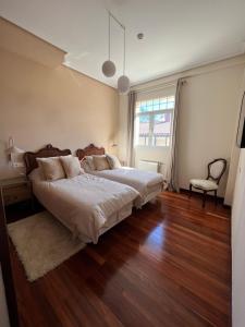 巴基奥Haizea的一间卧室设有一张大床,铺有木地板