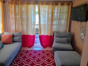 RibishiCays Inn Apartments的客厅配有窗帘、沙发和地毯。