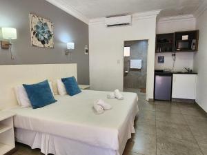 圣卢西亚Hippo Lodge Apartments的卧室配有带蓝色枕头的大型白色床