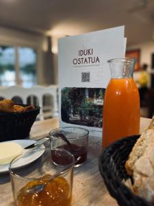 拉巴斯蒂德克莱朗斯伊杜克丘陵酒店的一张桌子,上面放着一瓶橙汁和面包
