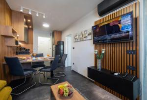扎达尔Jazine lux apartment E&T的客厅配有桌子和墙上的电视