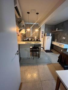 贝伦STUDIO 304 | WIFI 600MB | RESIDENCIAL JC, um lugar para ficar.的厨房配有桌椅和冰箱。