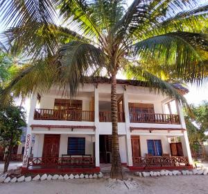 蓬圭圣玛丽亚珊瑚公园酒店的前面有棕榈树的建筑