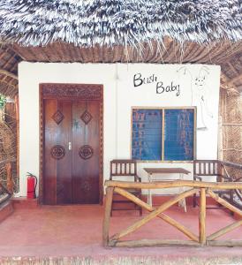 蓬圭圣玛丽亚珊瑚公园酒店的一座带长凳和标志的建筑,上面只读婴儿
