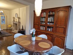 FrameriesGîte de charme dans une maison bourgeoise的一间带木桌和白色椅子的用餐室