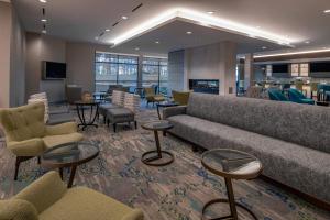 伦瑟姆TownePlace Suites By Marriott Wrentham Plainville的大堂设有大沙发、椅子和桌子
