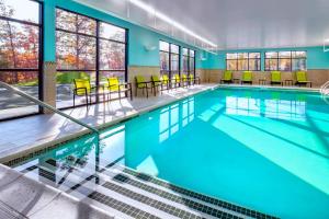 伦瑟姆TownePlace Suites By Marriott Wrentham Plainville的大楼内一个带桌椅的游泳池