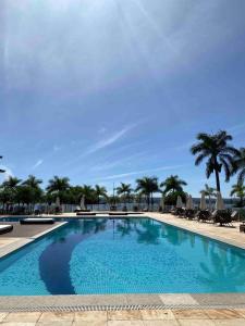 巴西利亚Refúgio Beira Lago- Life Resort的一个带椅子和棕榈树的大型游泳池