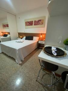巴西利亚Harmonia à Beira do Lago - Life Resort的一间卧室配有一张床和一张桌子及椅子