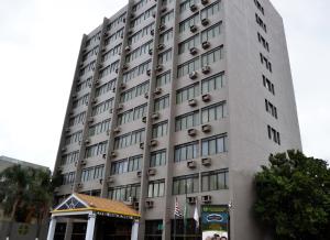 里贝朗普雷托Hotel Nacional Inn Ribeirão Preto的一座高大的灰色建筑,前面有一个凉亭