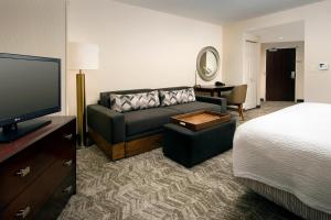 杰克逊维尔SpringHill Suites by Marriott Jacksonville North I-95 Area的酒店客房设有沙发、床和电视。