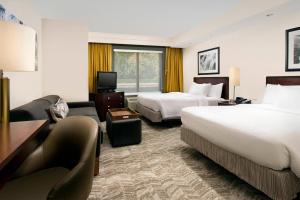 杰克逊维尔SpringHill Suites by Marriott Jacksonville North I-95 Area的酒店客房,设有两张床和一张沙发