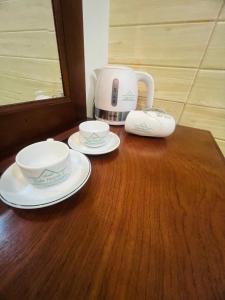 朔庄XUÂN HUỲNH 3 Hotel的一张带两个盘子的木桌和咖啡壶