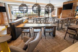 安大略SpringHill Suites by Marriott Ontario Airport/Rancho Cucamonga的一间带桌椅的餐厅和一间酒吧