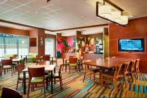 弗拉特罗克Fairfield Inn & Suites by Marriott Hendersonville Flat Rock的一间带桌椅和电视的用餐室