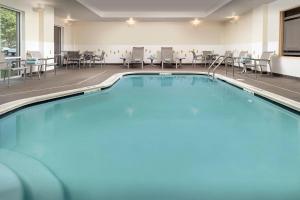 林夕昆高地巴尔的摩华盛顿国际机场费尔菲尔德客栈的游泳池位于酒店客房内,配有桌椅