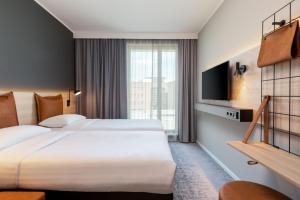 多特蒙德Moxy Dortmund City的一间酒店客房,设有两张床和电视