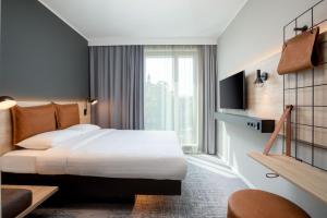 多特蒙德Moxy Dortmund City的酒店客房设有一张床和一个大窗户