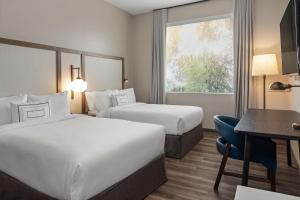 阿拉胡埃拉Fairfield by Marriott San Jose Airport Alajuela的酒店客房配有两张床和一张书桌