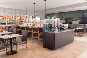 查尔斯顿TownePlace Suites by Marriott Charleston Airport/Convention Center的一间带桌椅和柜台的餐厅