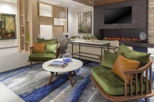 柯林斯堡Fairfield Inn & Suites by Marriott Fort Collins South的客厅配有两把椅子和壁炉