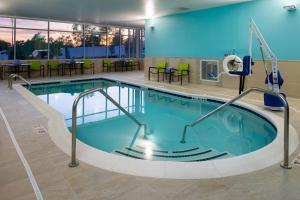 堪萨斯城SpringHill Suites by Marriott Kansas City Northeast的游泳池位于酒店带桌椅的客房内
