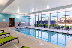 哥伦比亚SpringHill Suites by Marriott Columbia的一个带绿色桌椅的游泳池