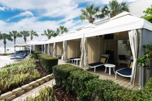 克利尔沃特Clearwater Beach Marriott Suites on Sand Key的连排小屋,配有桌椅和棕榈树
