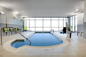 埃姆斯SpringHill Suites by Marriott Ames的一座带大窗户的建筑中的游泳池