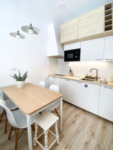 锡尼什Beach & Castle - Sines Apartment的厨房配有木桌和白色橱柜。