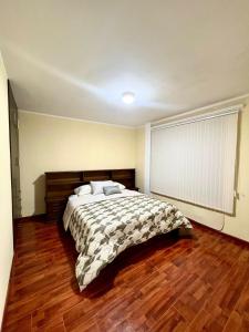 苏克雷Departamento de Patricia的一间卧室配有一张床,铺有木地板